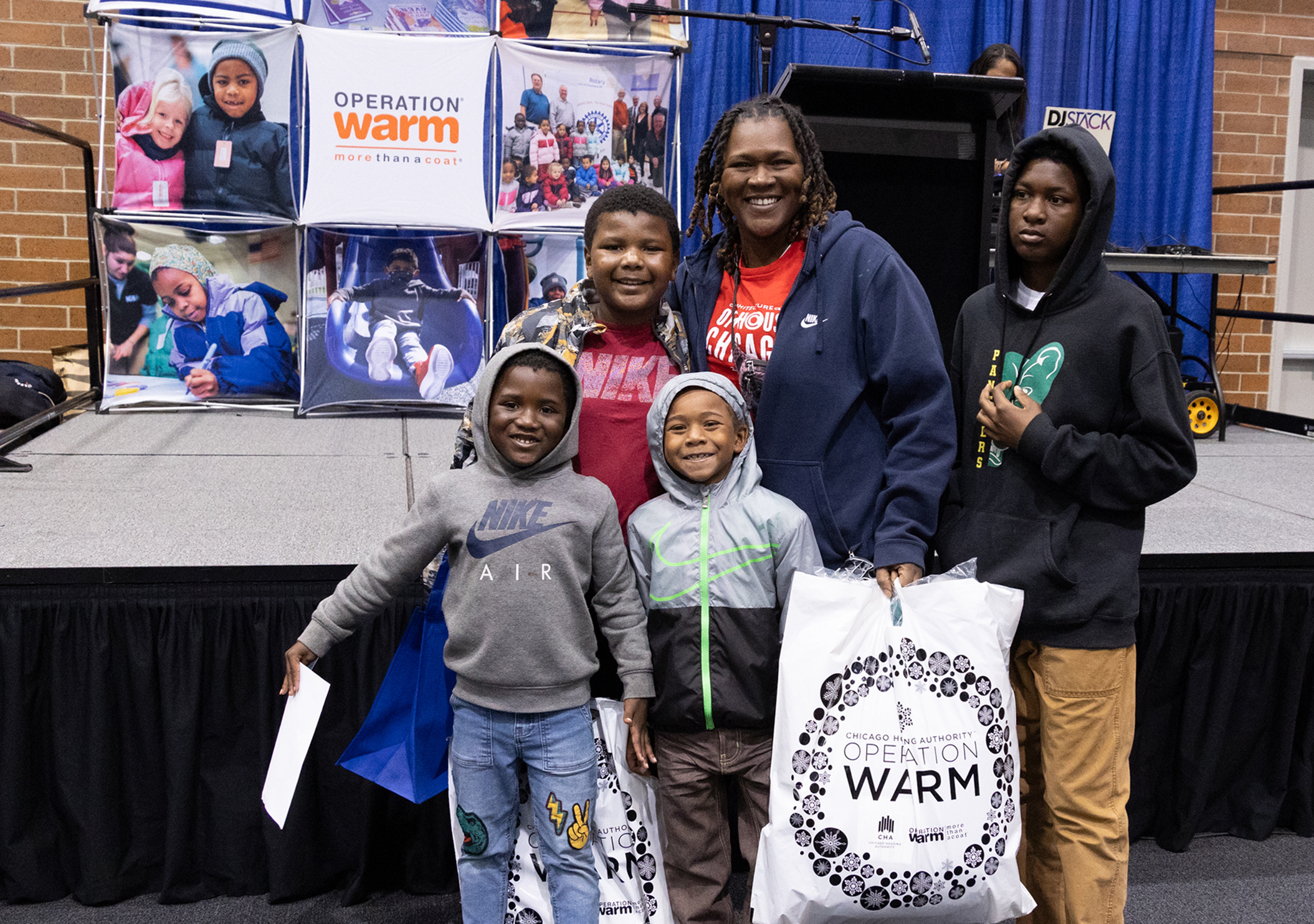 A family of five staanding in front of the Operation Warm stage.