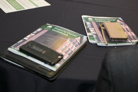 Two HCV Property Owner Guidebooks on a table covered with a black tablecloth.